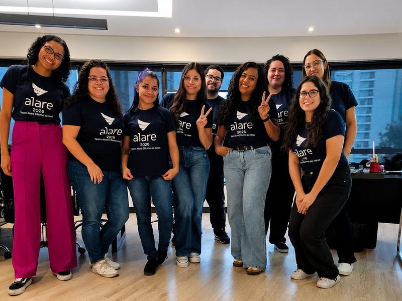 Grupo da equipe da Alare com a camiseta do time, no escritório